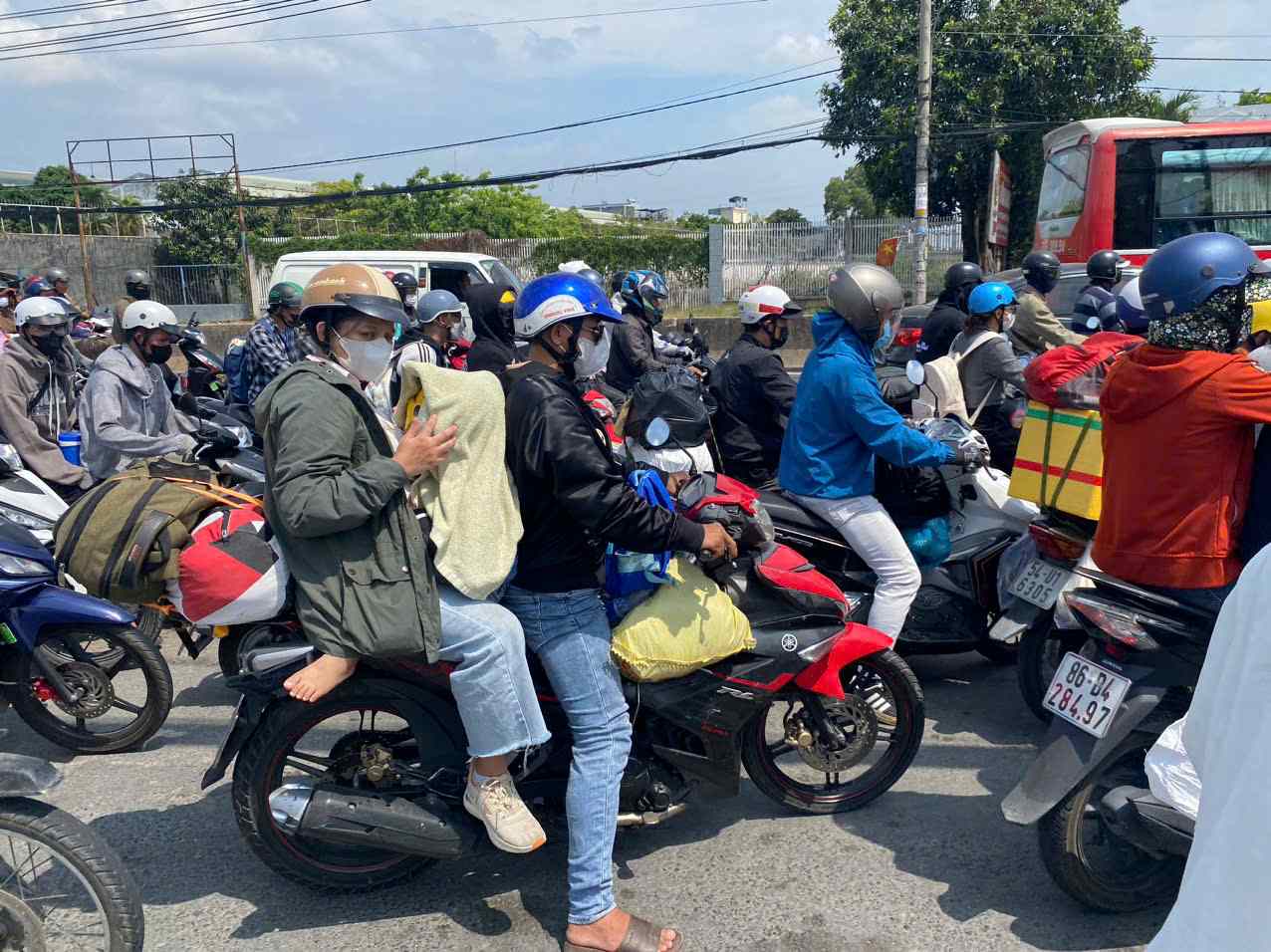 Các phương tiện di chuyển chậm, mang theo đồ đạc lỉnh kỉnh từ quê nhà lên TPHCM. Ảnh: Chân Phúc