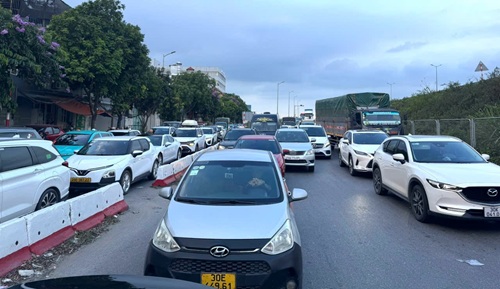 Les gens affluent à Hanoï, la circulation à la porte d'entrée est surchargée. Photo: Long Phi