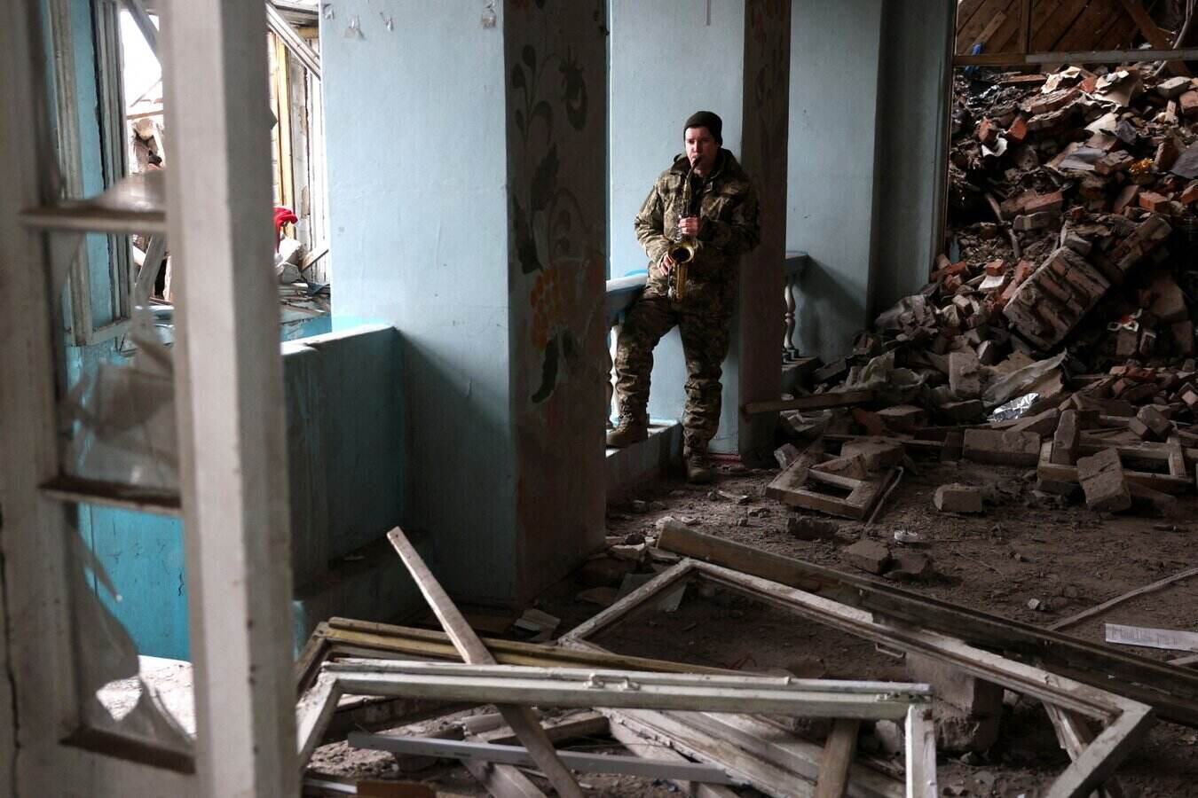 A Ukrainian soldier plays saxophone at a school building destroyed by a missile attack in Kostiantynivka in late 2023 amid the Russia-Ukraine conflict. Photo: AFP