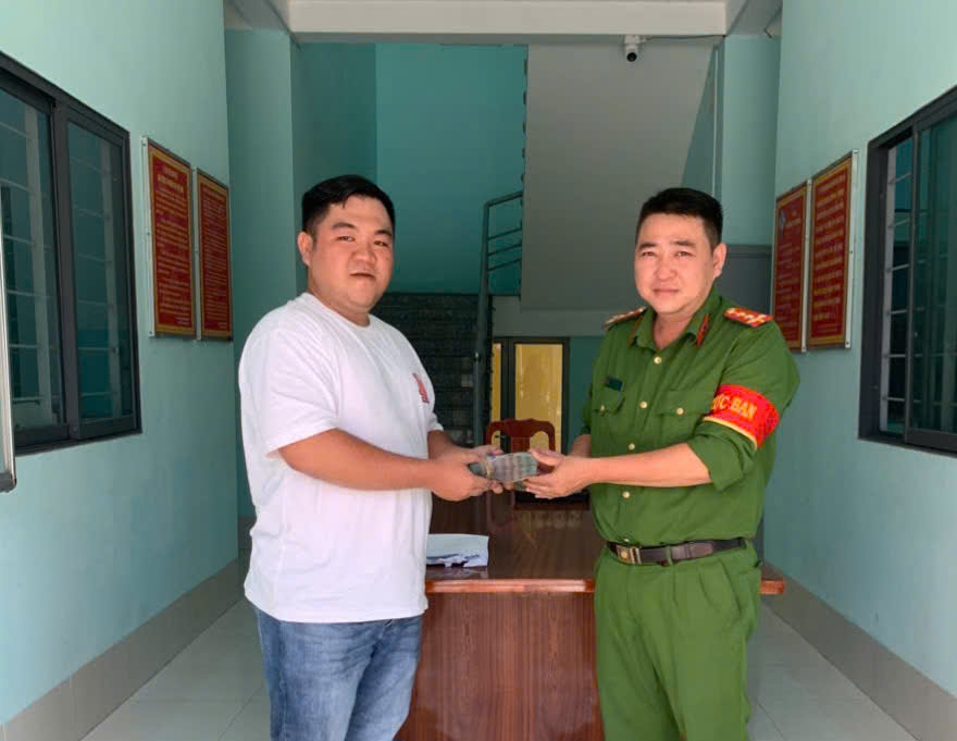 Mr. Nguyen Bao Long receives the money that was mistakenly transferred. Photo: Police provided