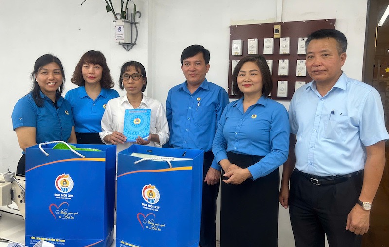 Vice President of the Vietnam General Confederation of Labour Nguyen Xuan Hung (4th from left) and leaders of the Industry Trade Union, leaders of May 10 Corporation - JSC, May 10 Corporation - JSC Trade Union present gifts from the 14th Vietnam Trade Union Congress to Ms. Dang Thi Tu (3rd from left) at her workplace. Photo: Kieu Vu