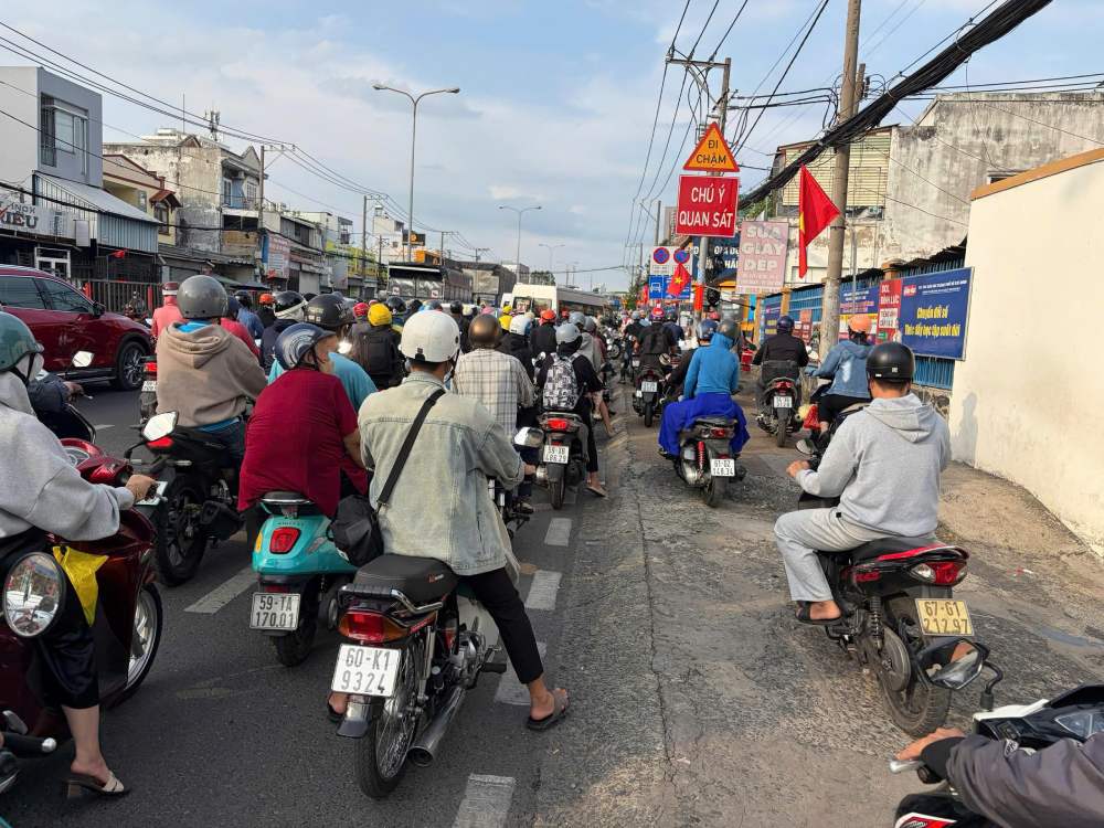  Xe máy xếp hàng di chuyển tại quốc lộ 1K. Ảnh: Anh Tú