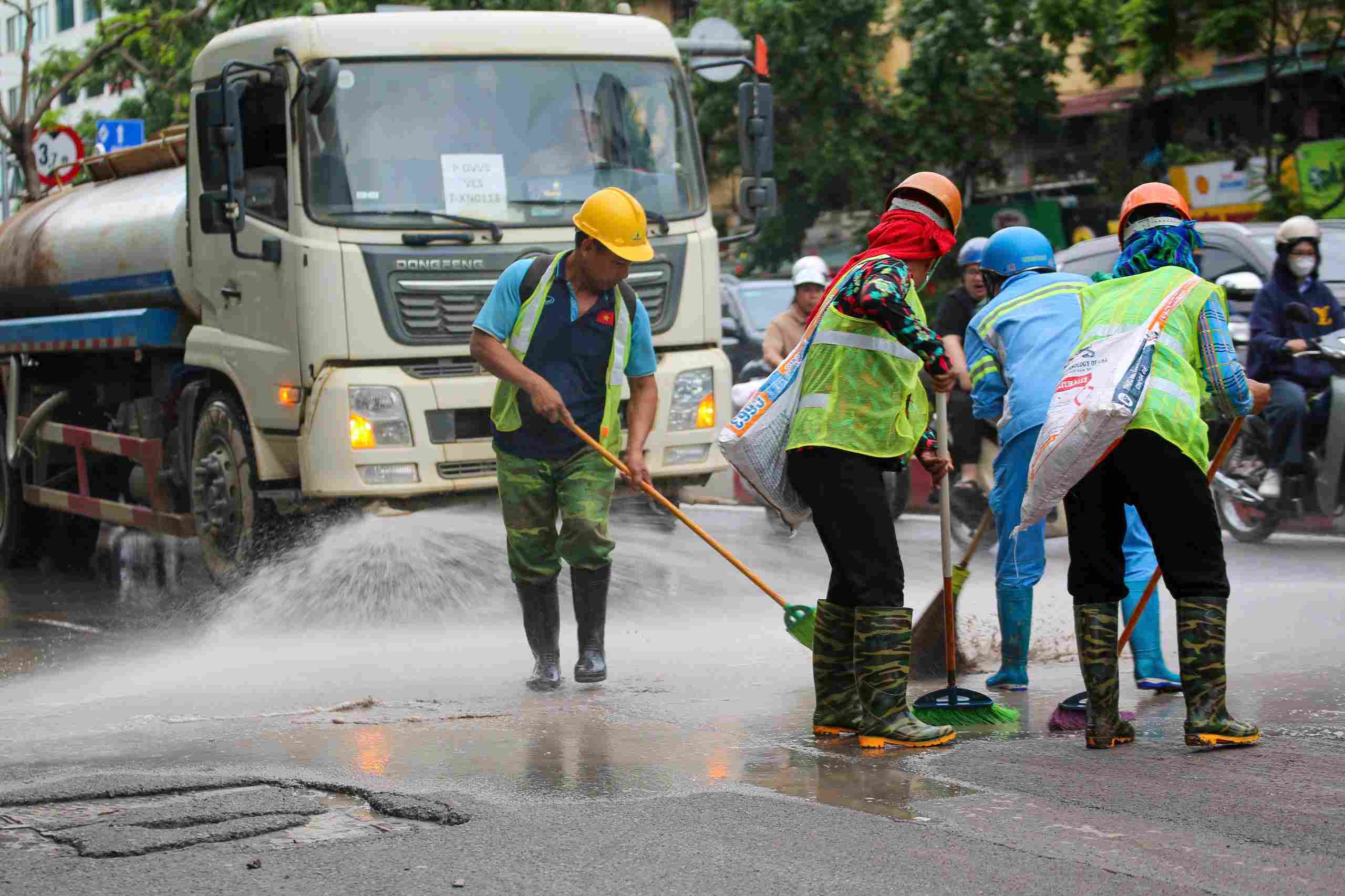 Bùn đất trên đường được dọn rửa. Ảnh: Tiến Ngô
