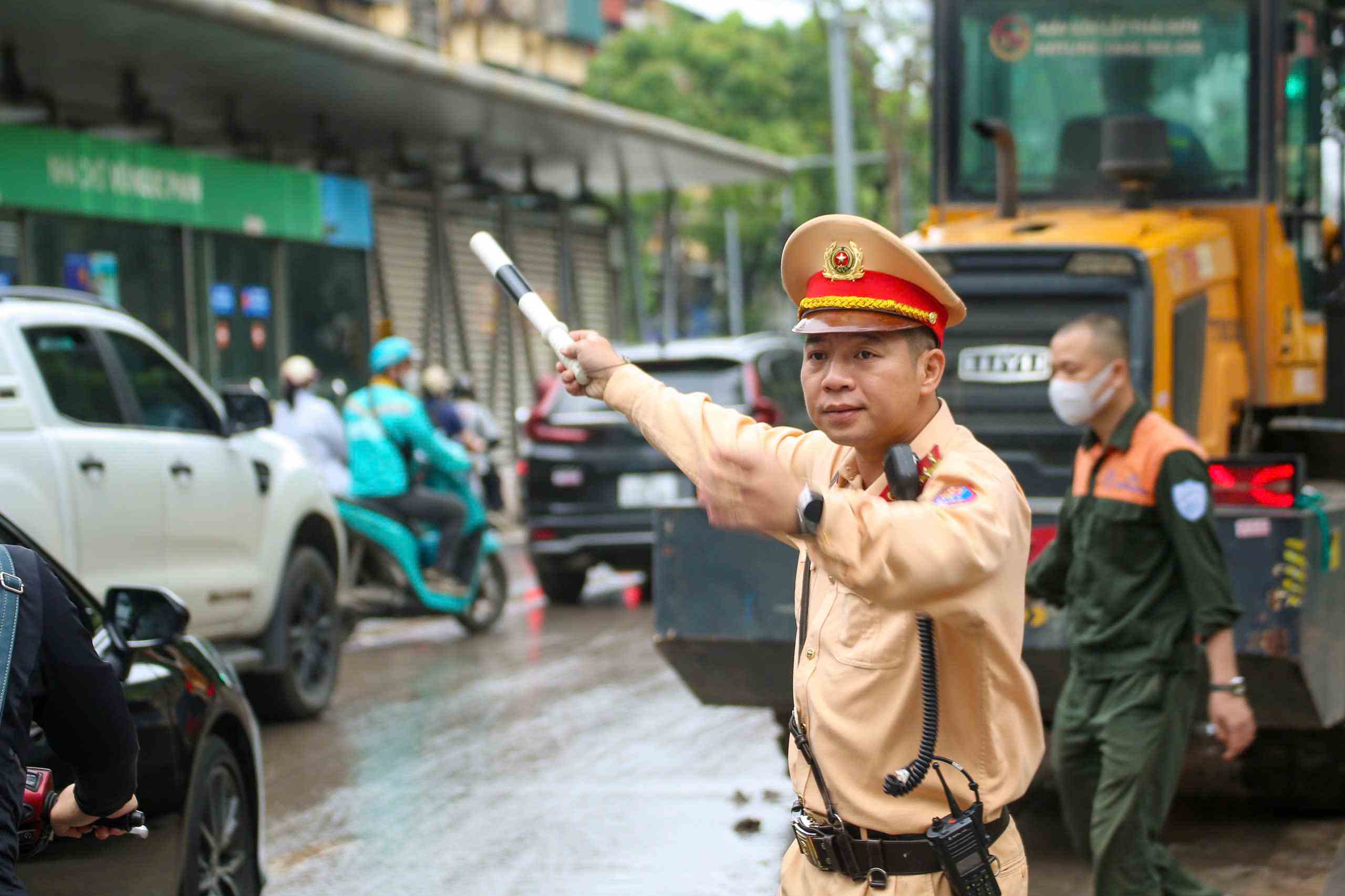 Cảnh sát giao thông điều tiết giao thông qua khu vực bùn đất rơi vãi. Ảnh: Tiến Ngô