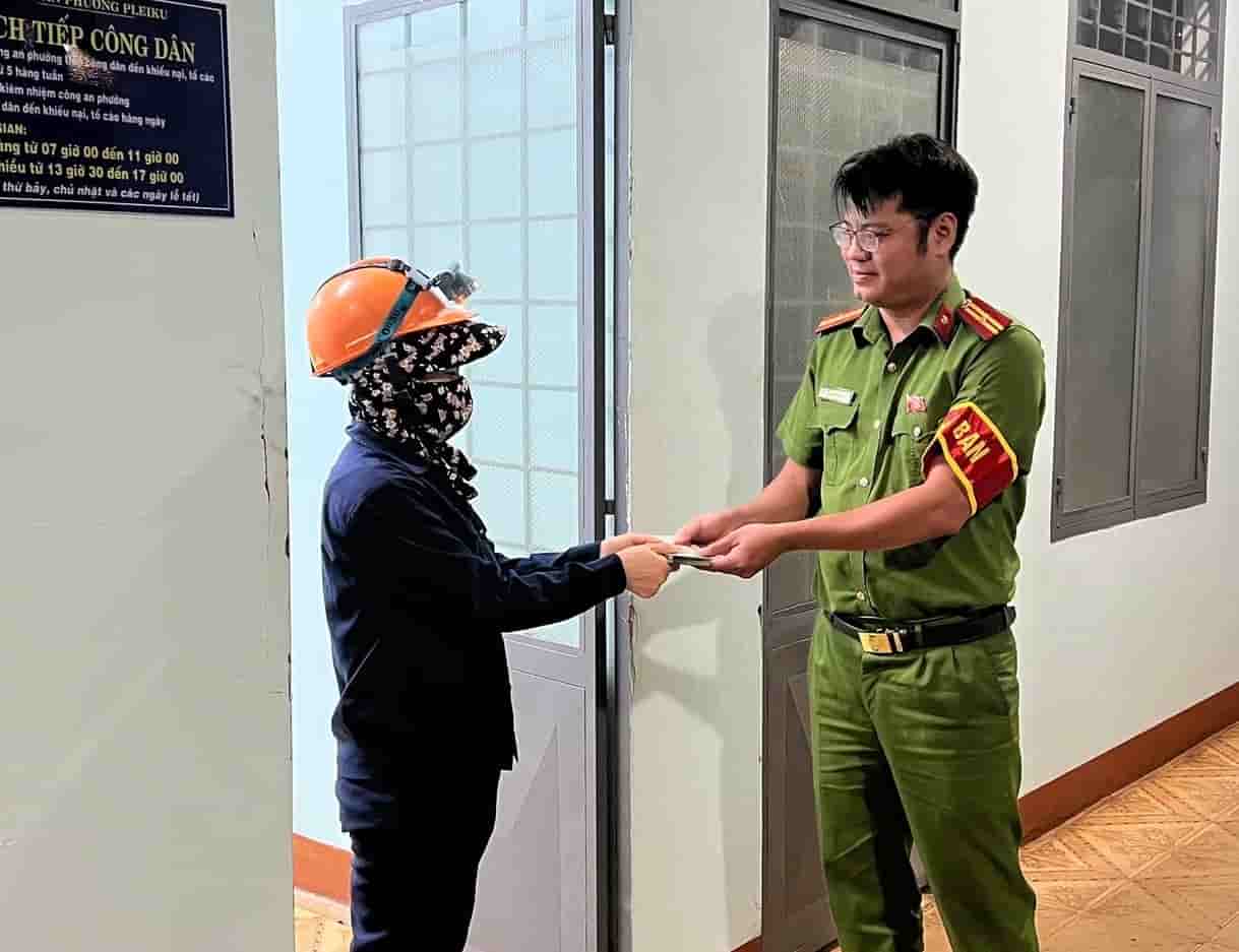 Female worker Anh Hong returns the stack of money to the police agency to find the person who dropped it. Photo: Thanh Tuan