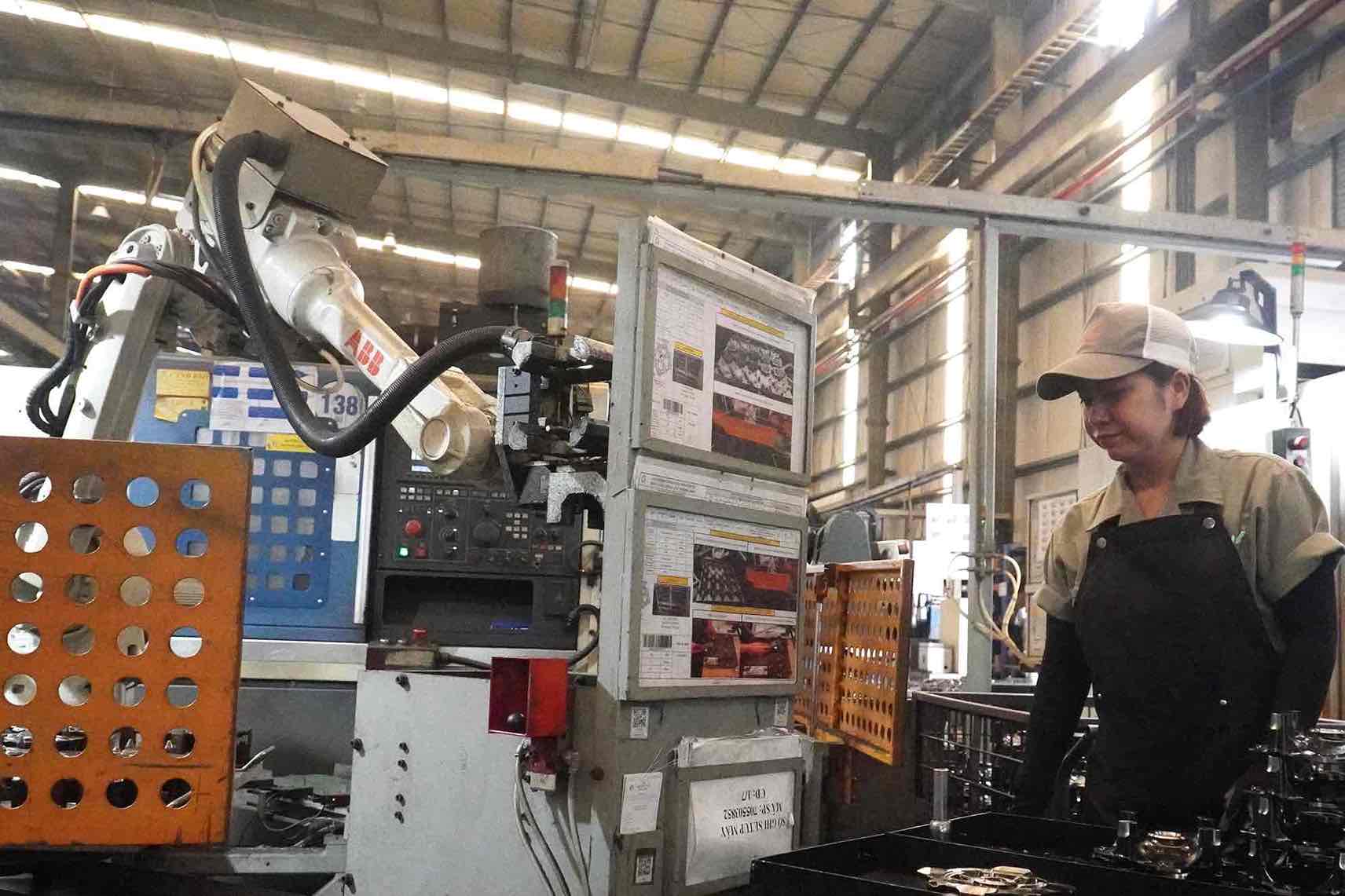 Chị Kim Phượng, nữ lao động Công ty hữu hạn Cơ khí động lực Toàn Cầu đang vận hành máy CNC. Ảnh: HAC