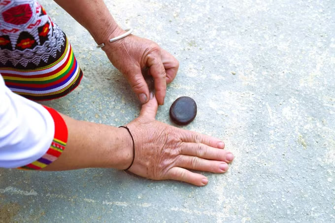 To mang" - a Thai folk game, using the bounce of fingers to shoot mang seeds forward to hit the target. Photo: Xuan Tien/VNA