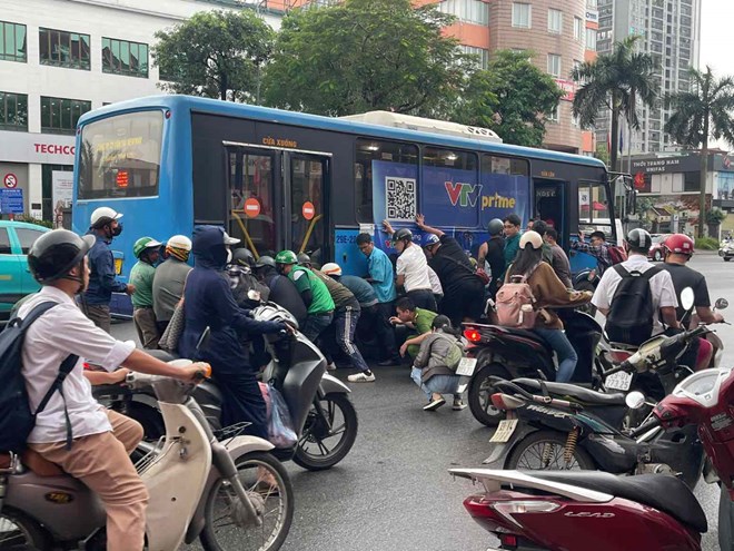 Người phụ nữ mắc kẹt trong gầm xe buýt ở khu vực ngã tư Nguyễn Sơn - Nguyễn Văn Cừ. Ảnh: Công an cung cấp