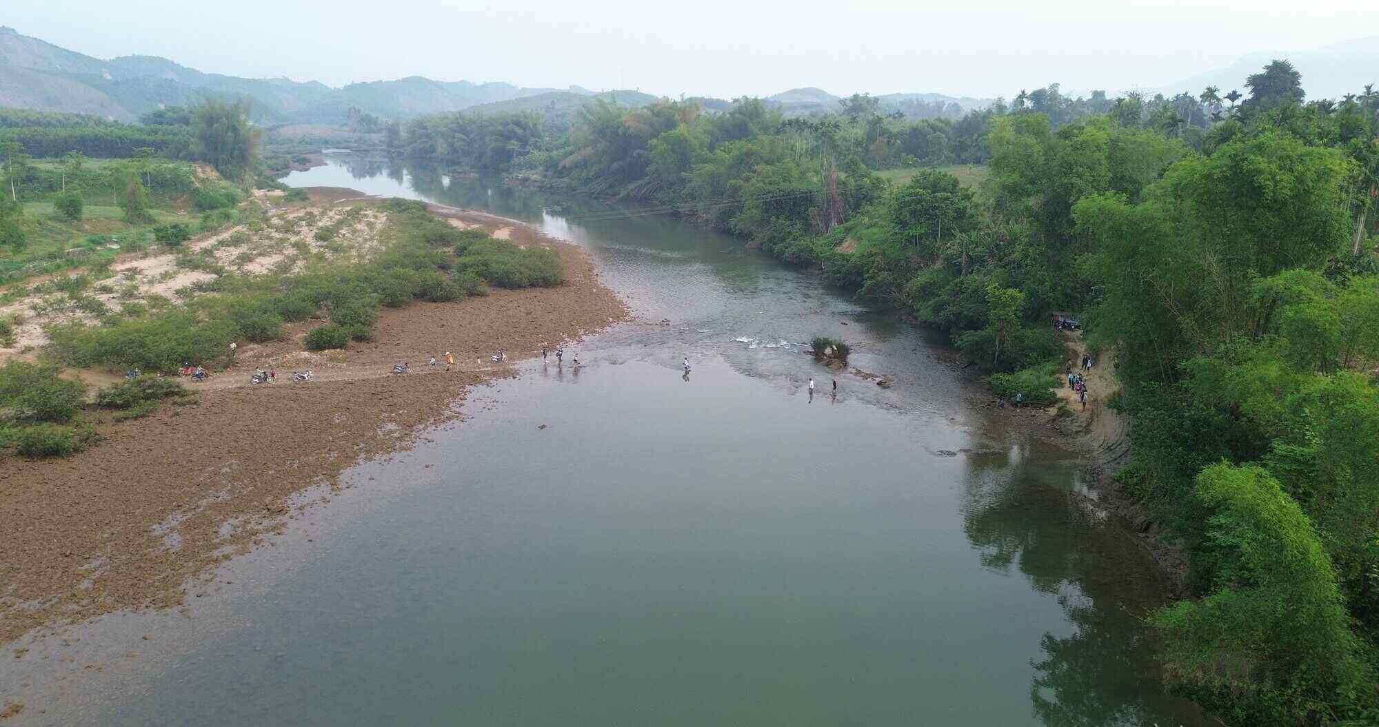 Sáng sớm trên bờ sông Xà Lò (đoạn qua xóm Bà Rà, thôn Làng Trăng, xã Sơn Thủy, tỉnh Quảng Ngãi), nhiều phụ huynh đã có mặt để cõng con đến trường. Ảnh: Đông Giang