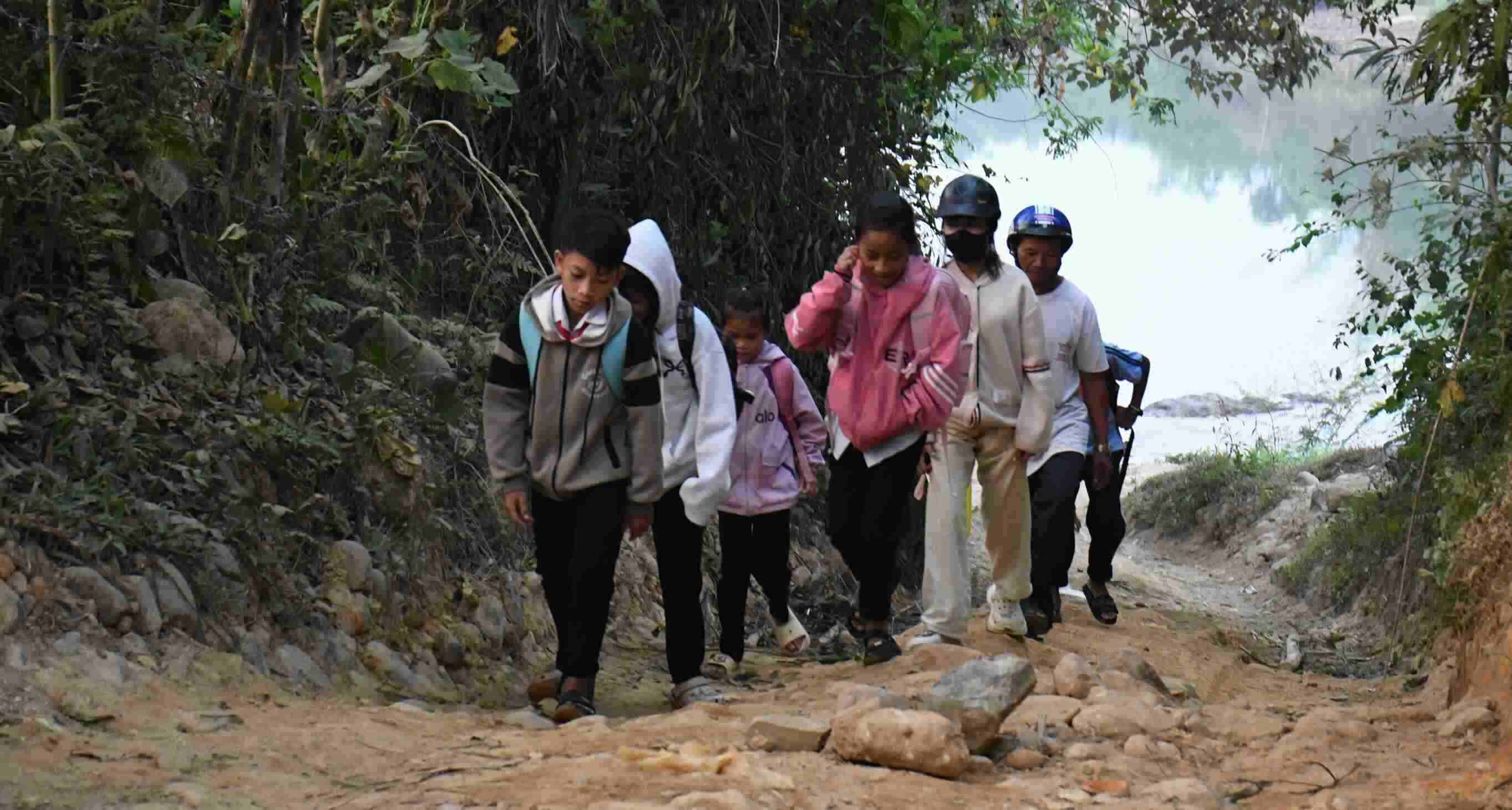 Sau khi vượt sông, các em vẫn phải đi bộ thêm khoảng 2km đường rừng mới tới lớp. Ảnh: Đông Giang