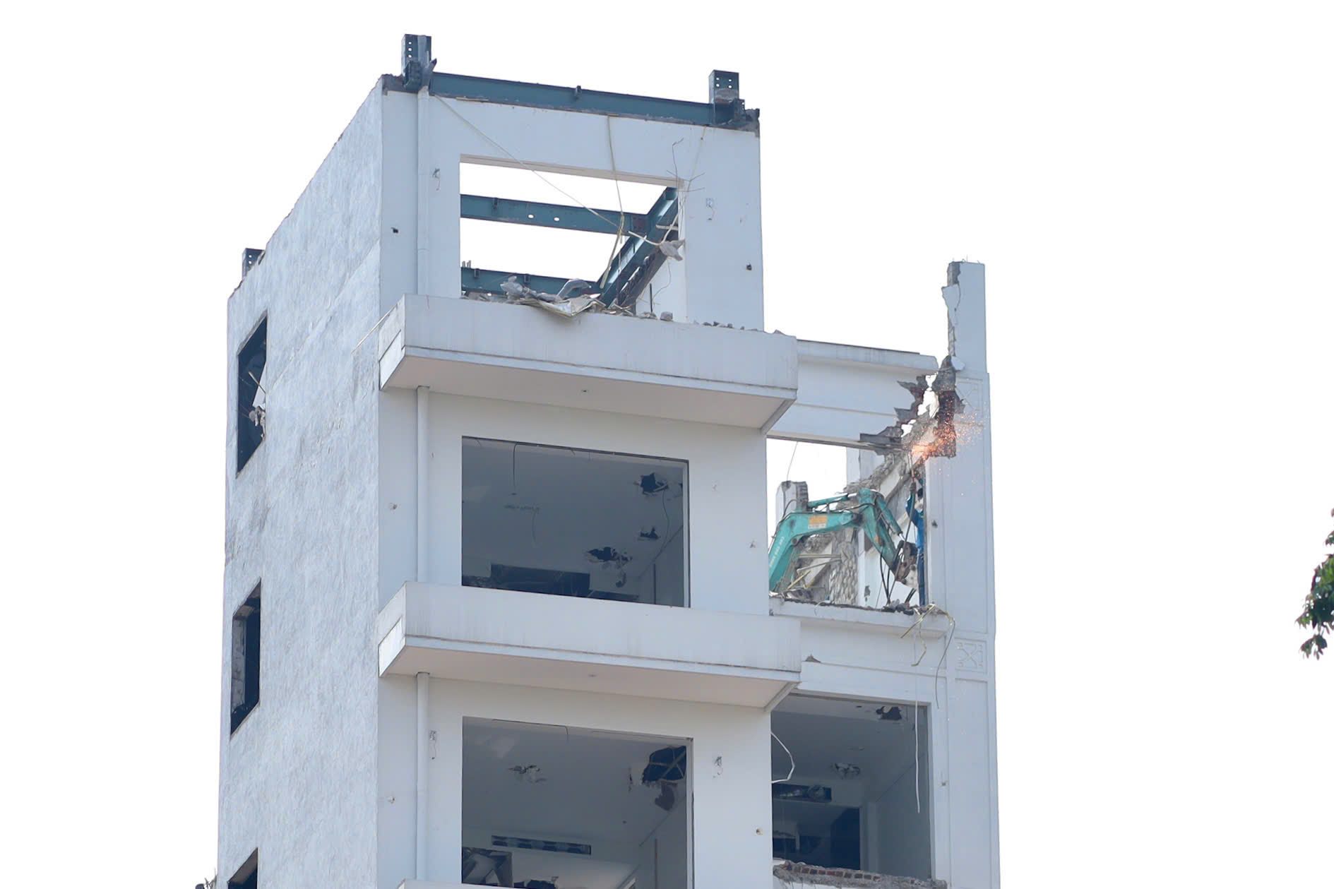 Máy xúc gắn búa thủy lực được cẩu lên mái, liên tục đục phá các lớp bê tông giúp đẩy nhanh tiến độ tháo dỡ công trình. Ảnh: Kim Thủy