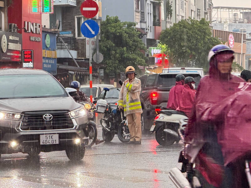 Lực lượng công an điều tiết giao thông do mưa dông xảy ra đúng giờ cao điểm, khiến việc di chuyển của người dân gặp nhiều khó khăn. Ảnh: Hạ Mây