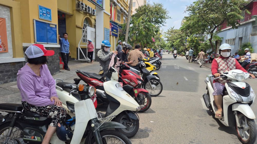 Phụ huynh Trường Tiểu học Đặng Thùy Trâm chờ đón học sinh về ăn trưa ngày 5.5. Ảnh: Chân Phúc
