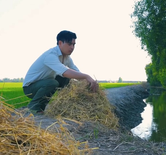 Hồ Quang Hiếu tự tay nướng cá giữa đồng quê. Ảnh: Cắt từ video