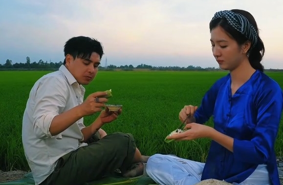 Ho Quang Hieu and his wife enjoy grilled fish. Photo: Cut from video.
