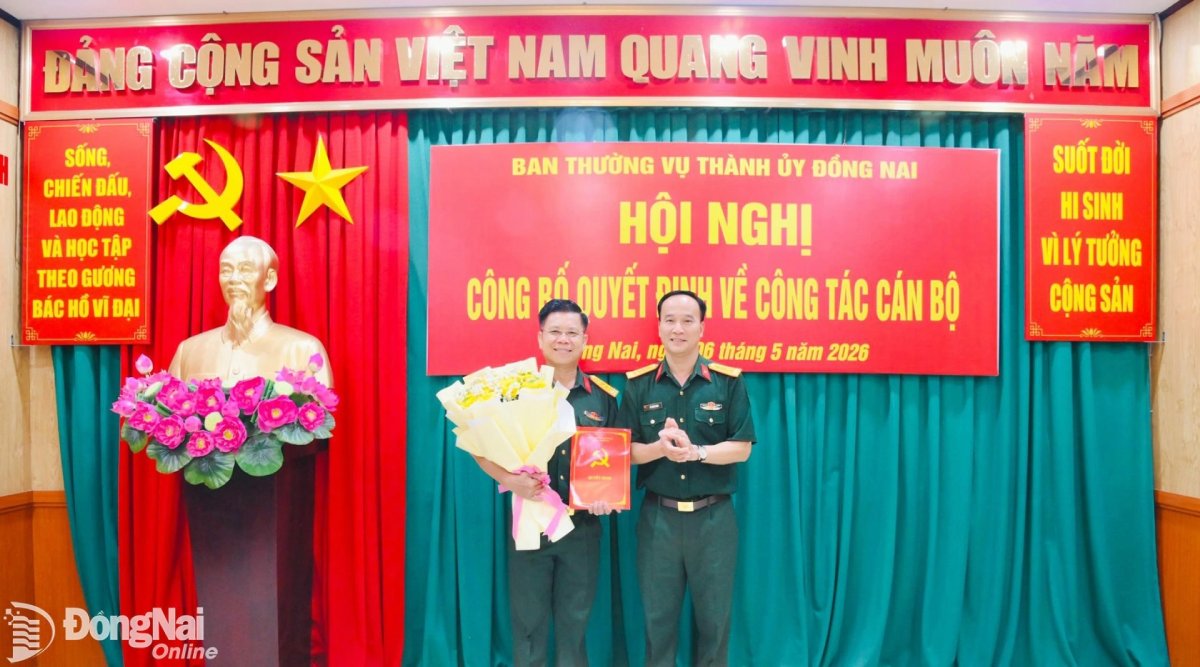 Đại tá Võ Thành Danh - Ủy viên Ban Thường vụ Thành ủy, Chỉ huy trưởng Bộ Chỉ huy Quân sự thành phố Đồng Nai trao quyết định và tặng hoa chúc mừng Đại tá Nguyễn Thanh Phong. Ảnh: dongnai.gov.vn 
