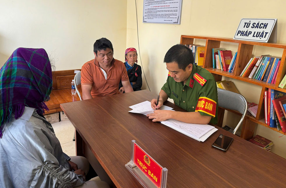 Cán bộ công an lấy thông tin của người phụ nữ đi lạc nhiều ngày. Ảnh: CA Lào Cai 