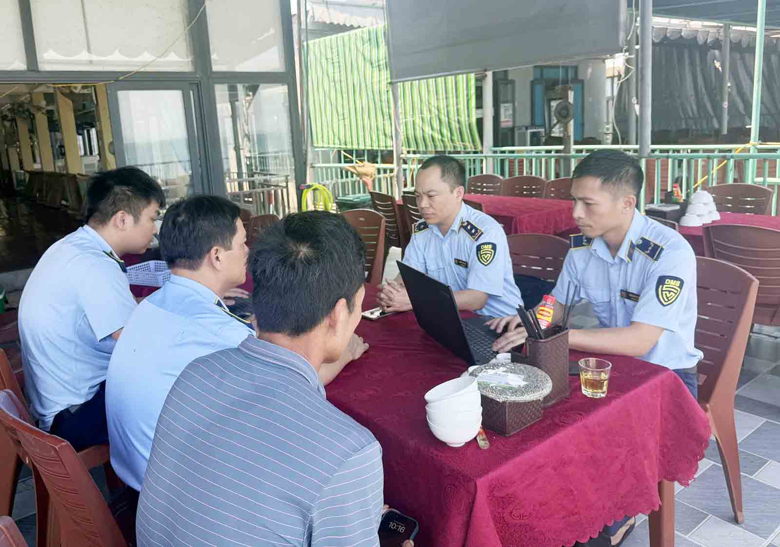 Lực lượng quản lý thị trường làm việc và xử phạt chủ nhà hàng Lý Hộ. Ảnh: Hoàng Anh