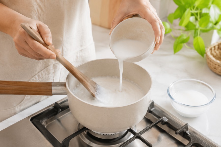Nước cốt dừa được nấu riêng, khuấy đều để đạt độ sánh mịn. Ảnh: Thùy Linh