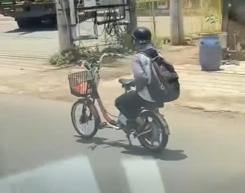 Teenager lets go of both hands while riding an electric bicycle on National Highway 13. Photo: cut from a clip provided by a reader