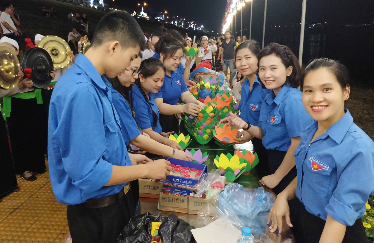 Đoàn viên thanh niên hỗ trợ thắp hoa đăng trên sông Đà. Ảnh: Đoàn thanh niên