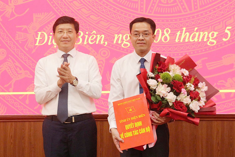 Deputy Secretary of Dien Bien Provincial Party Committee Mua A Vang presents the decision and flowers to congratulate the new Chief of Office of the Provincial Party Committee Trinh Hoang Thang. Photo: Lan Phuong
