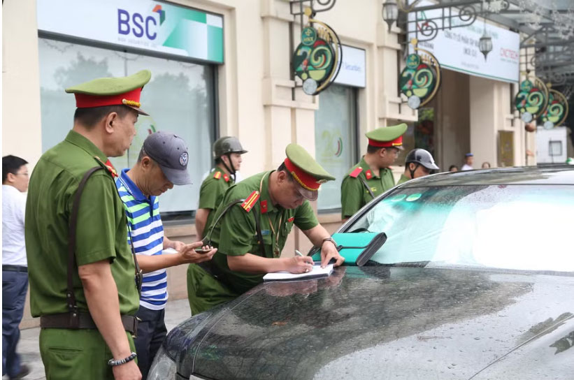 Cua Nam Ward Police make a record of a case of a car stopping and parking in violation of regulations. Photo: Dang Chung