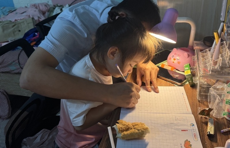 試験シーズン、親は子供たちと一緒に概要を作成し、文字を一つ一つ綴ります。写真:カイン・リン