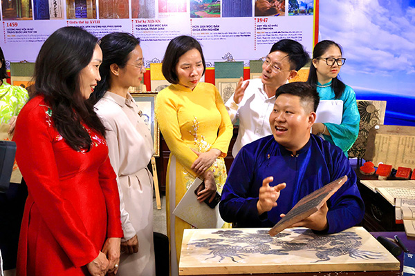 Delegates learn about woodblock carving art at the exhibition "Hai Phong in the flow of history through archival documents". Photo: Ngoc Huyen
