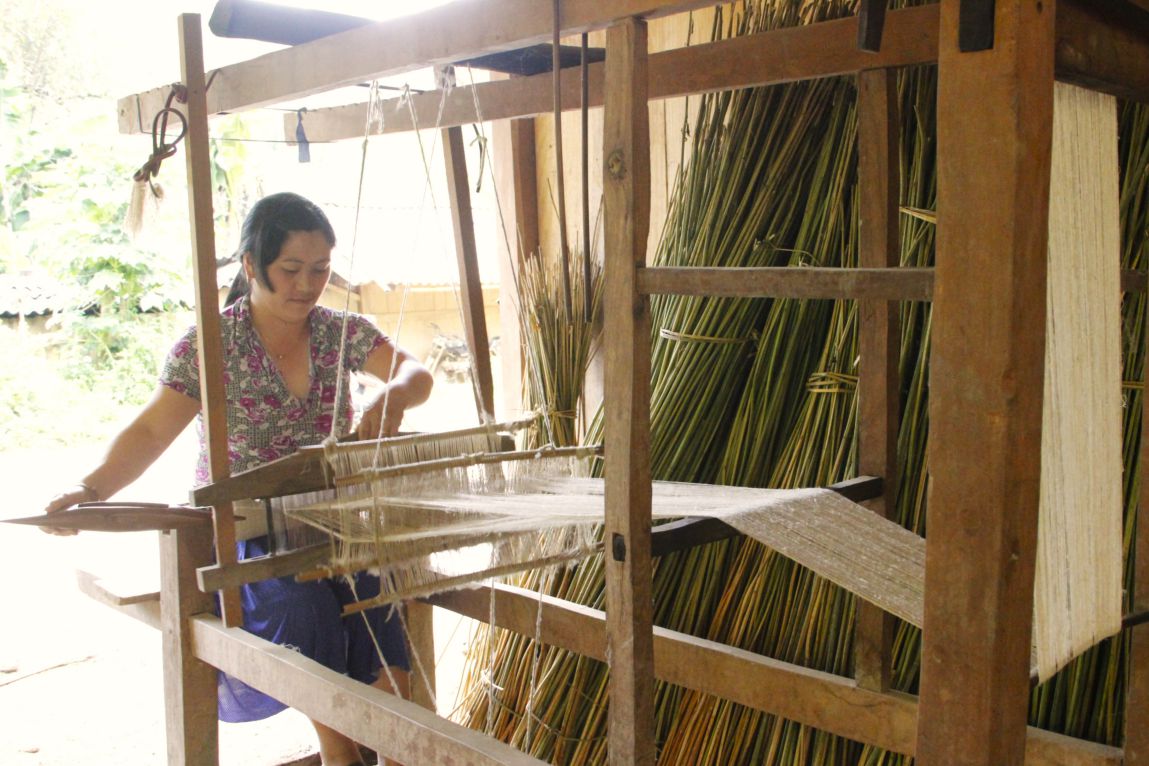 Người phụ nữ H’Mông miệt mài se lanh bên khung cửi, gìn giữ nghề truyền thống của dân tộc mình. Ảnh: Trường Sơn