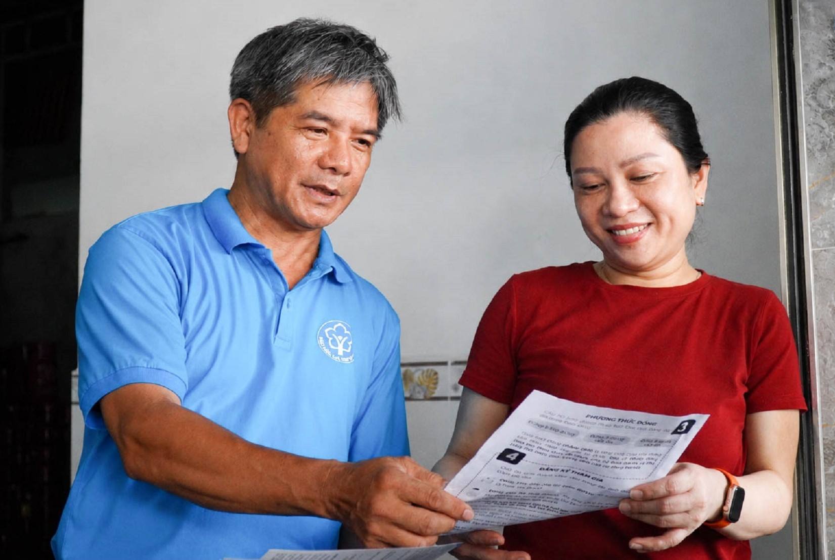 Cán bộ ngành BHXH trực tiếp đến khu dân cư tuyên truyền, vận động người dân tham gia BHXH sau lễ ra quân. Ảnh: Đông Giang