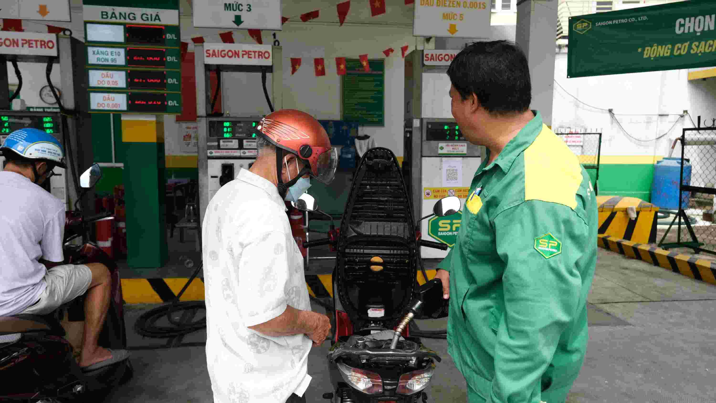 Ông Đỗ Thanh Hoàng vừa đổ xăng vừa tư vấn thêm về lợi ích sử dụng xăng E10. Ảnh: Phong Linh