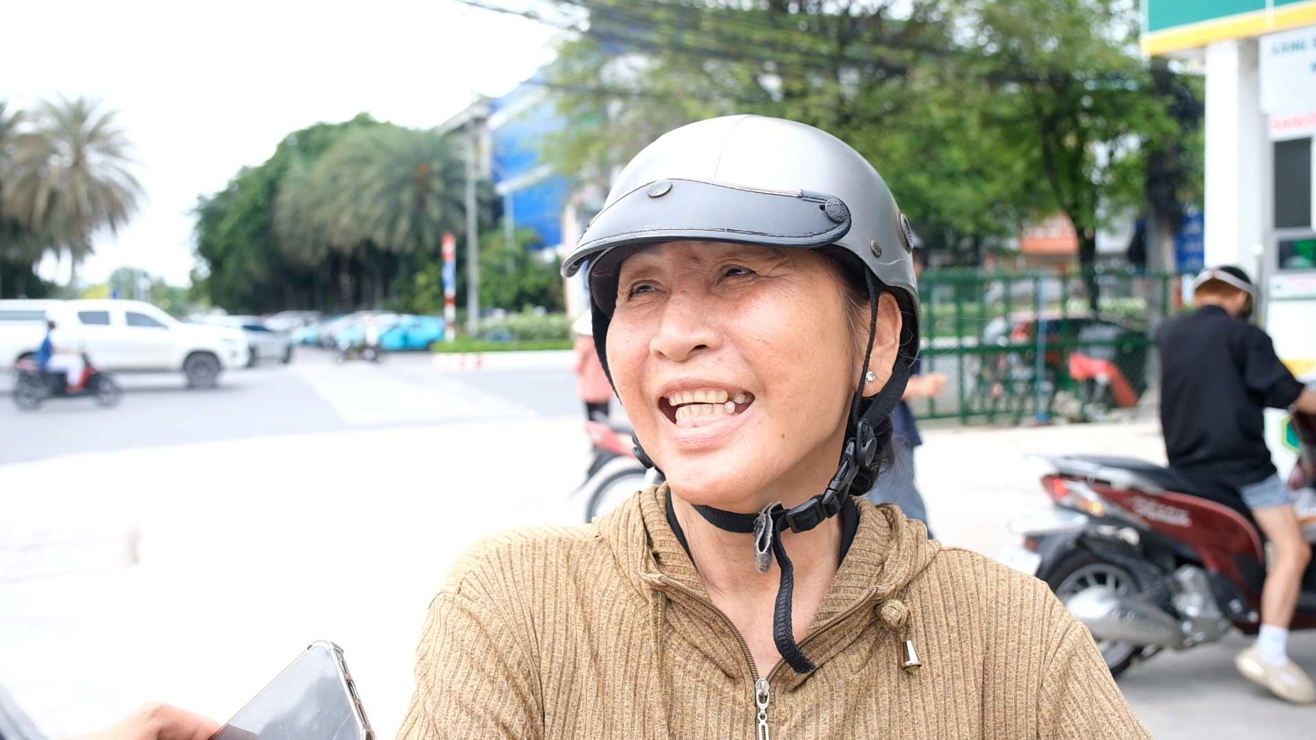 Bà Nguyễn Thị Huệ hứng khởi trong ngày đầu được sử dụng xăng sinh học giúp bảo vệ môi trường. Ảnh: Phong Linh 