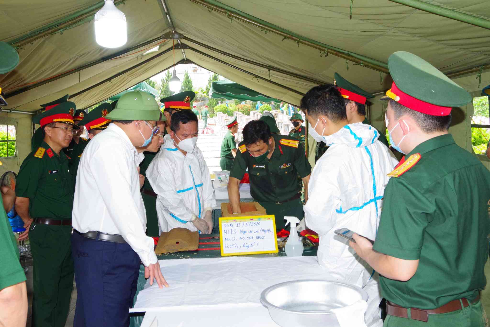Representatives of Nghe An Provincial People's Committee, Military Region 4 and functional forces inspect the work of taking biological samples of unidentified martyrs' remains for DNA testing. Photo: Trong Kien
