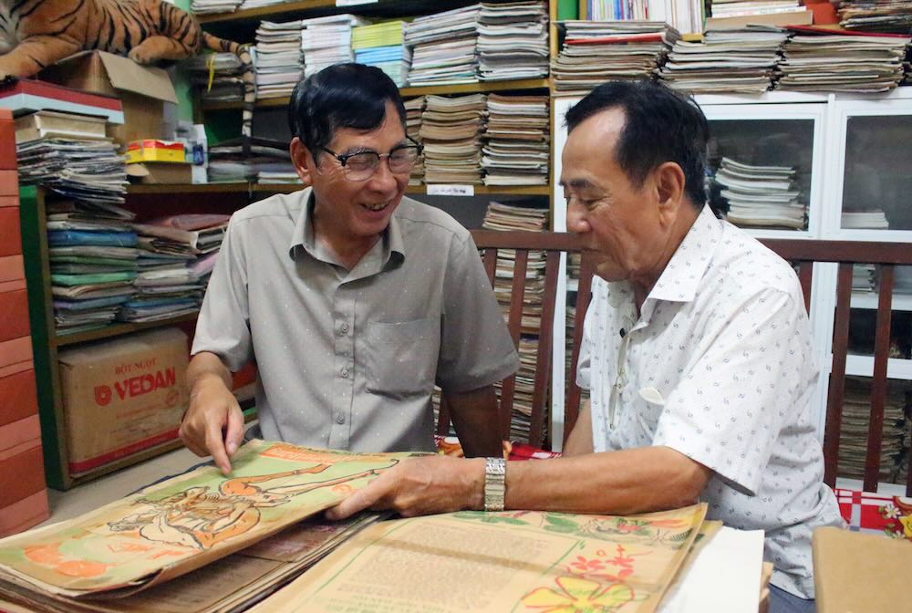 Nhà báo Ngô Hoàng Vân và nhà báo Trương Thanh Nhã (trái sang) chia sẻ cảm xúc khi xem lại những bài viết trên báo Chiến Thắng cách đây hơn nửa thế kỷ. Ảnh: Lục Tùng