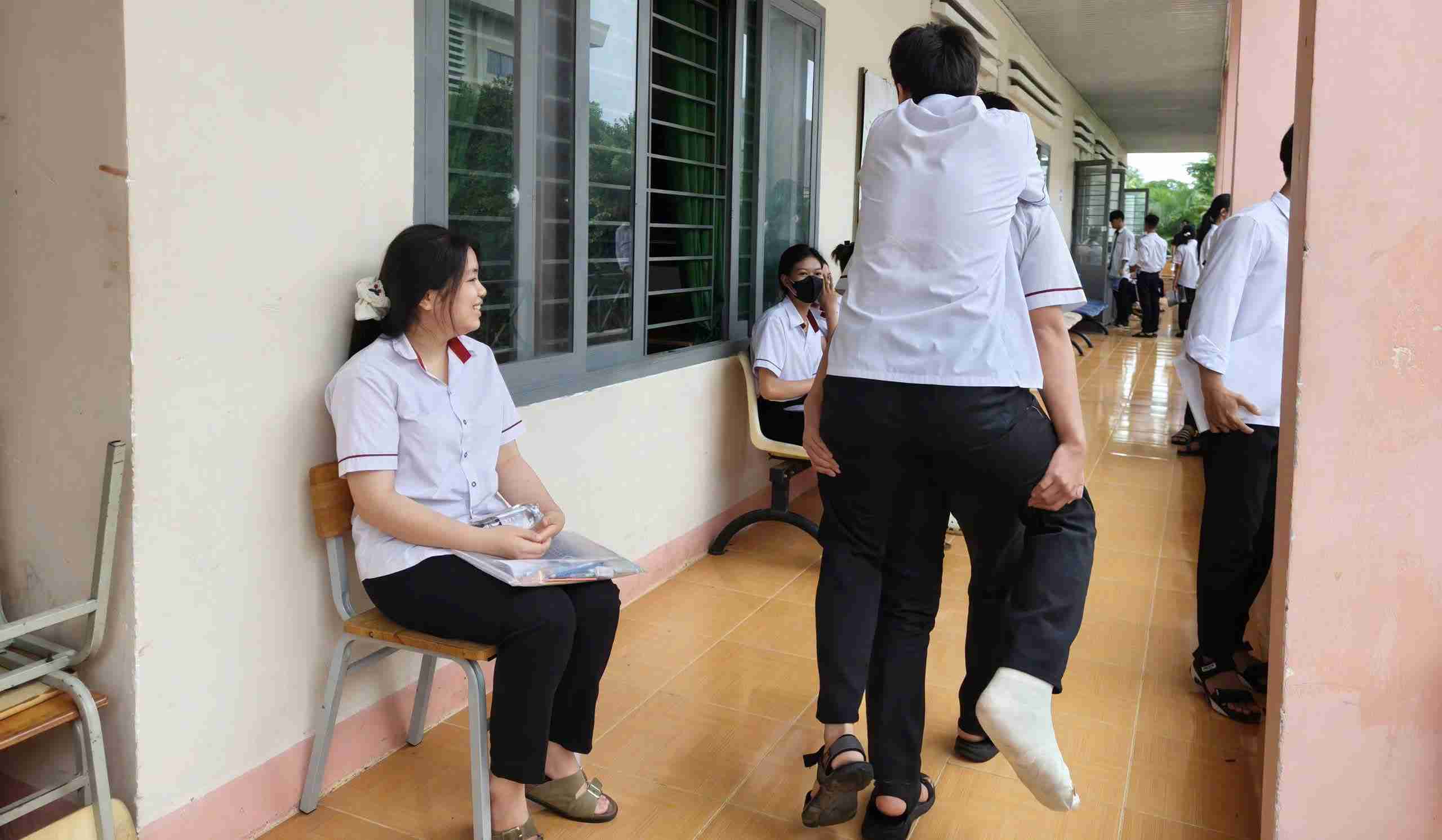 Images of a male student carrying a broken friend to the high school graduation exam room in Dak Lak touched many people. Photo: Bao Trung