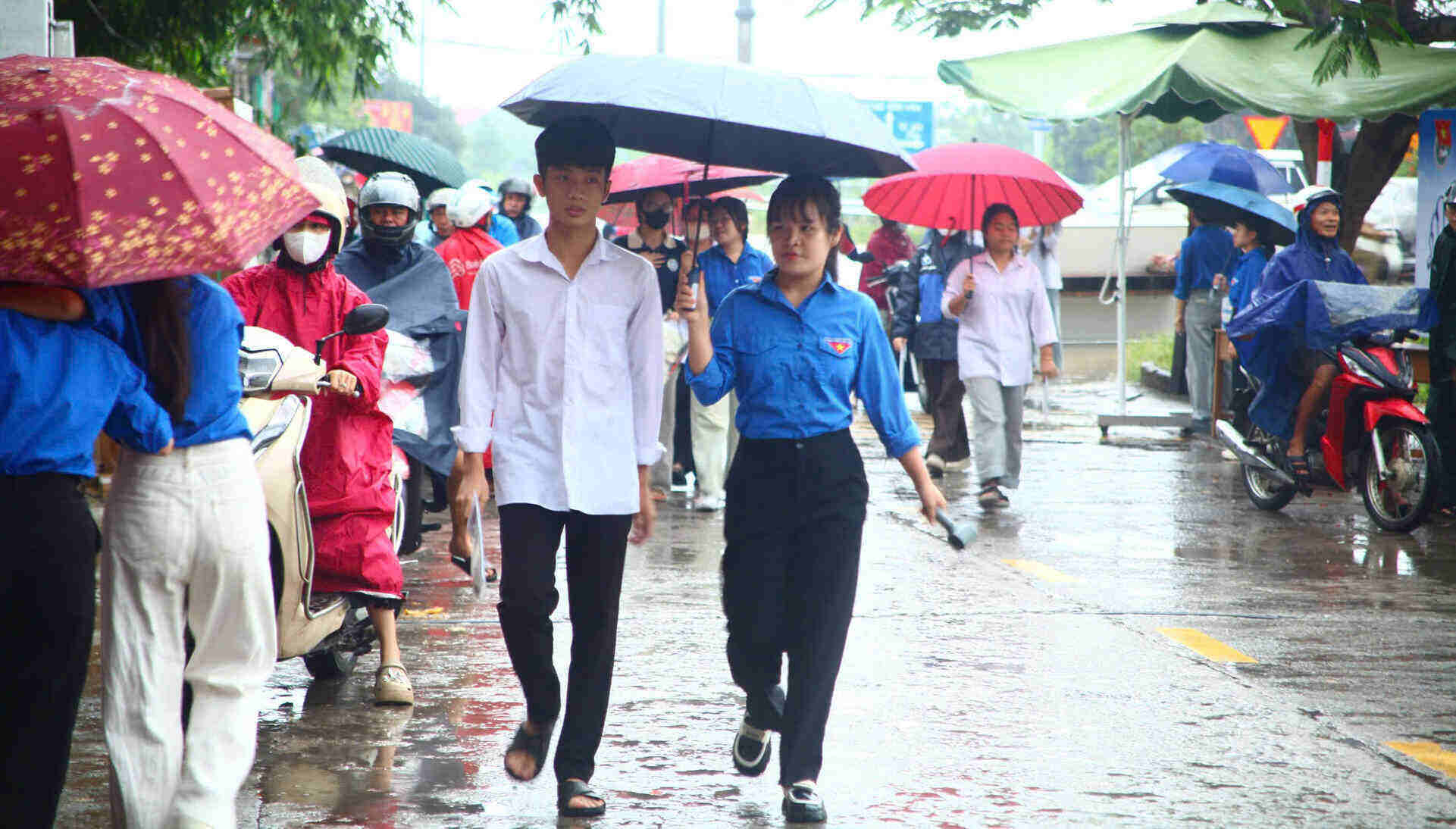 Các tình nguyện viên hỗ trợ thí sinh đến điểm thi. Ảnh: Diệu Anh