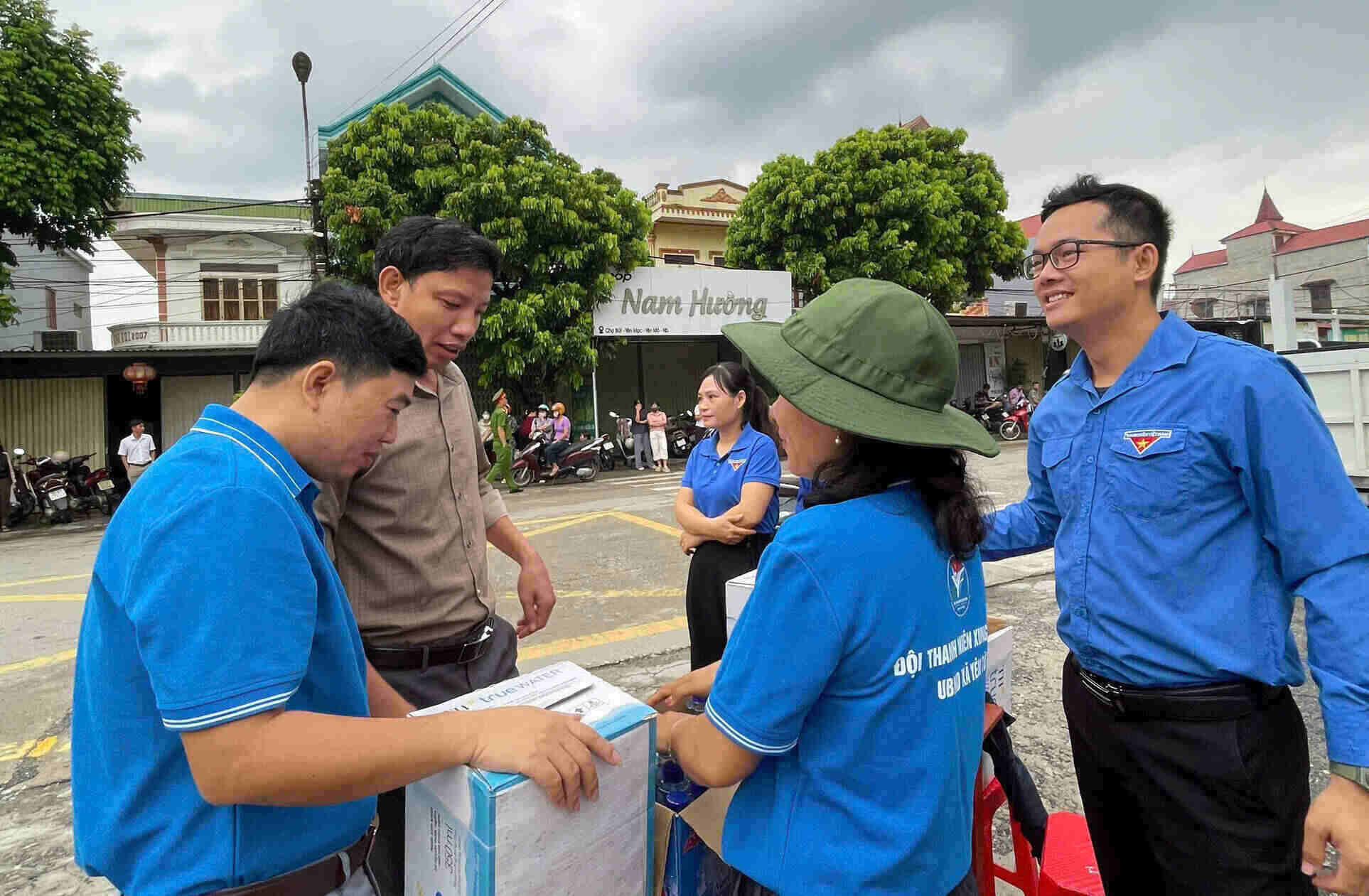 Các tình nguyện viên phát nước uống miễn phí cho người nhà thí sinh. Ảnh: Diệu Anh