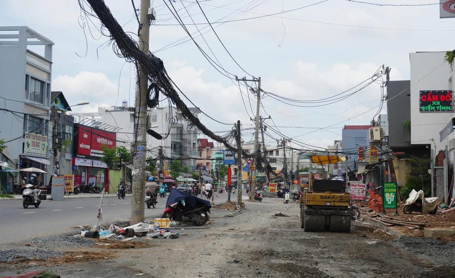 Images of unfinished construction, jagged soil and rocks, mud in front of people's houses. Photo: Nhu Quynh