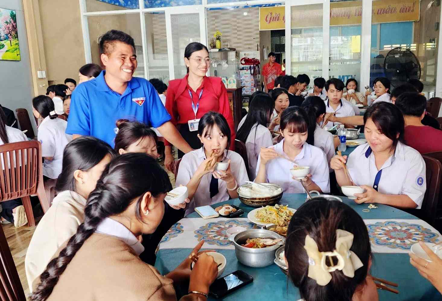 Lãnh đạo xã Quảng Khê tới thăm hỏi, động viên thí sinh tại khu ăn tập thể dành cho thí sinh khó khăn. Ảnh: Thần Hy 
