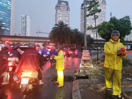 Công nhân Công ty Thoát nước Hà Nội ứng trực trong mưa lớn. Ảnh: Minh Hạnh 
