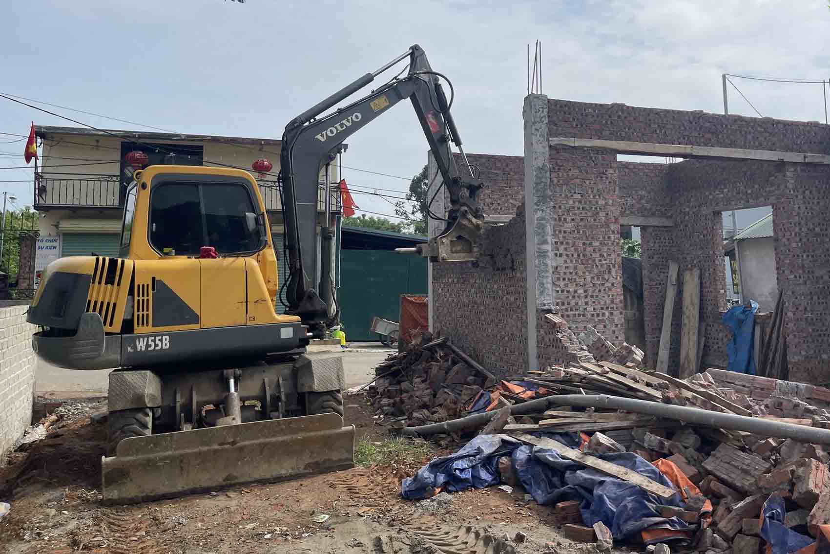 Lực lượng chức năng tháo dỡ công trình vi phạm xây dựng trên đất nông nghiệp của bà T.T.L. Ảnh: Xã Phú Cát 