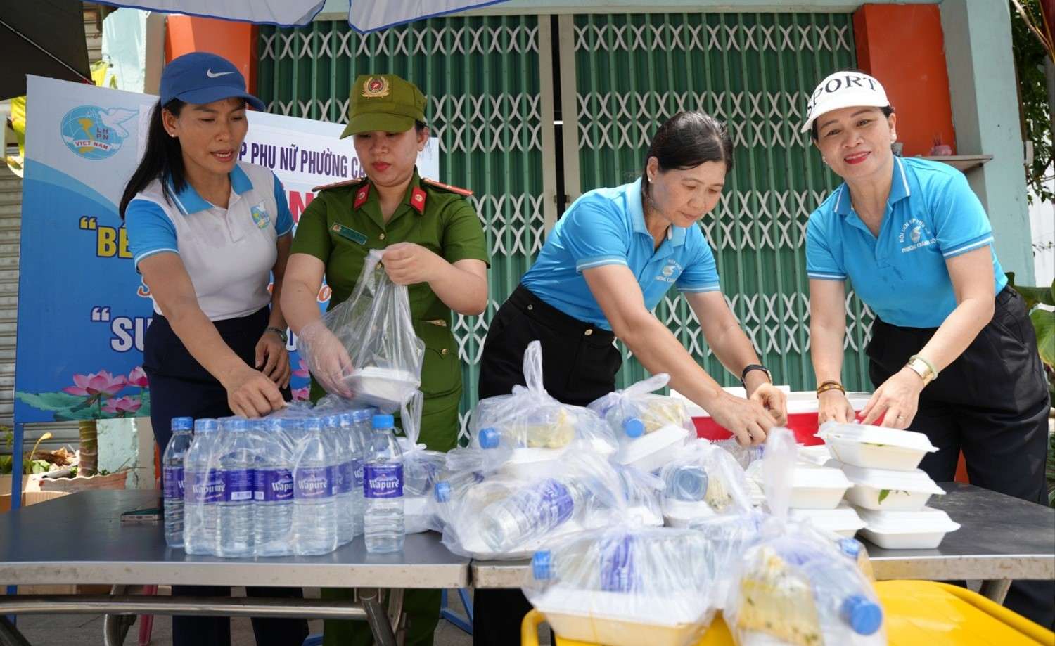 Hội viên phụ nữ phường Cẩm Thành cùng lực lượng công an chuẩn bị hơn 200 suất cơm nghĩa tình để trao đến người dân có hoàn cảnh khó khăn. Ảnh: Hoài Thuận