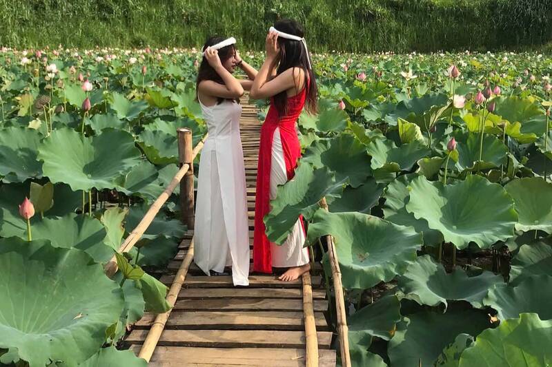 Du khách chụp ảnh tại hồ sen bản Buốt, xã Chiềng Mai. Ảnh: Văn Quyến