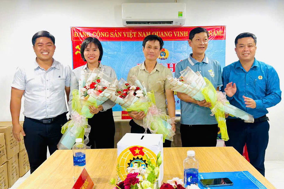 Mr. Doan Thanh Binh (right) - Chairman of Tuy Phuoc Commune Trade Union - presents flowers to congratulate the Executive Committee of the grassroots Trade Union of Binh Dinh Cotton Production Co., Ltd. Photo: Thanh Binh