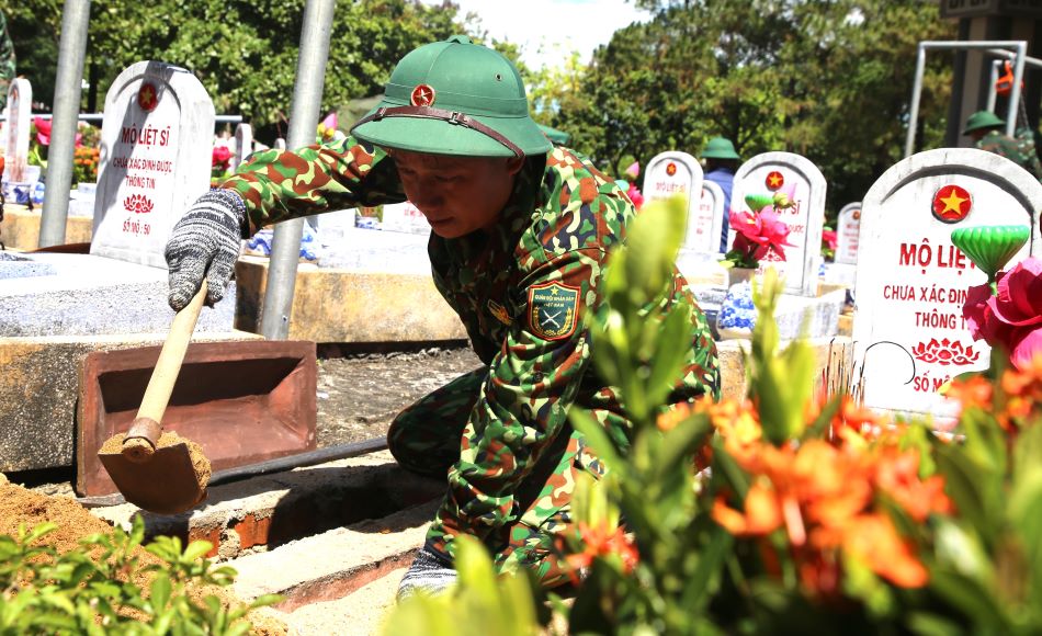 Members of Team 584 perform the task of taking samples for DNA testing at the martyr's grave where information has not been identified. Photo: Hung Tho