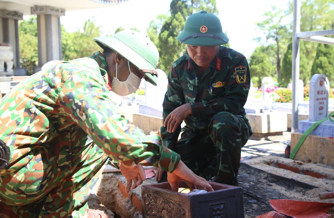 Trung tá Ngô Thanh Liêm (bên phải ảnh), Đội trưởng Đội 584 cùng một chiến sĩ thực hiện nhiệm vụ tại Nghĩa trang liệt sĩ Quốc gia Đường 9. Ảnh: Hưng Thơ