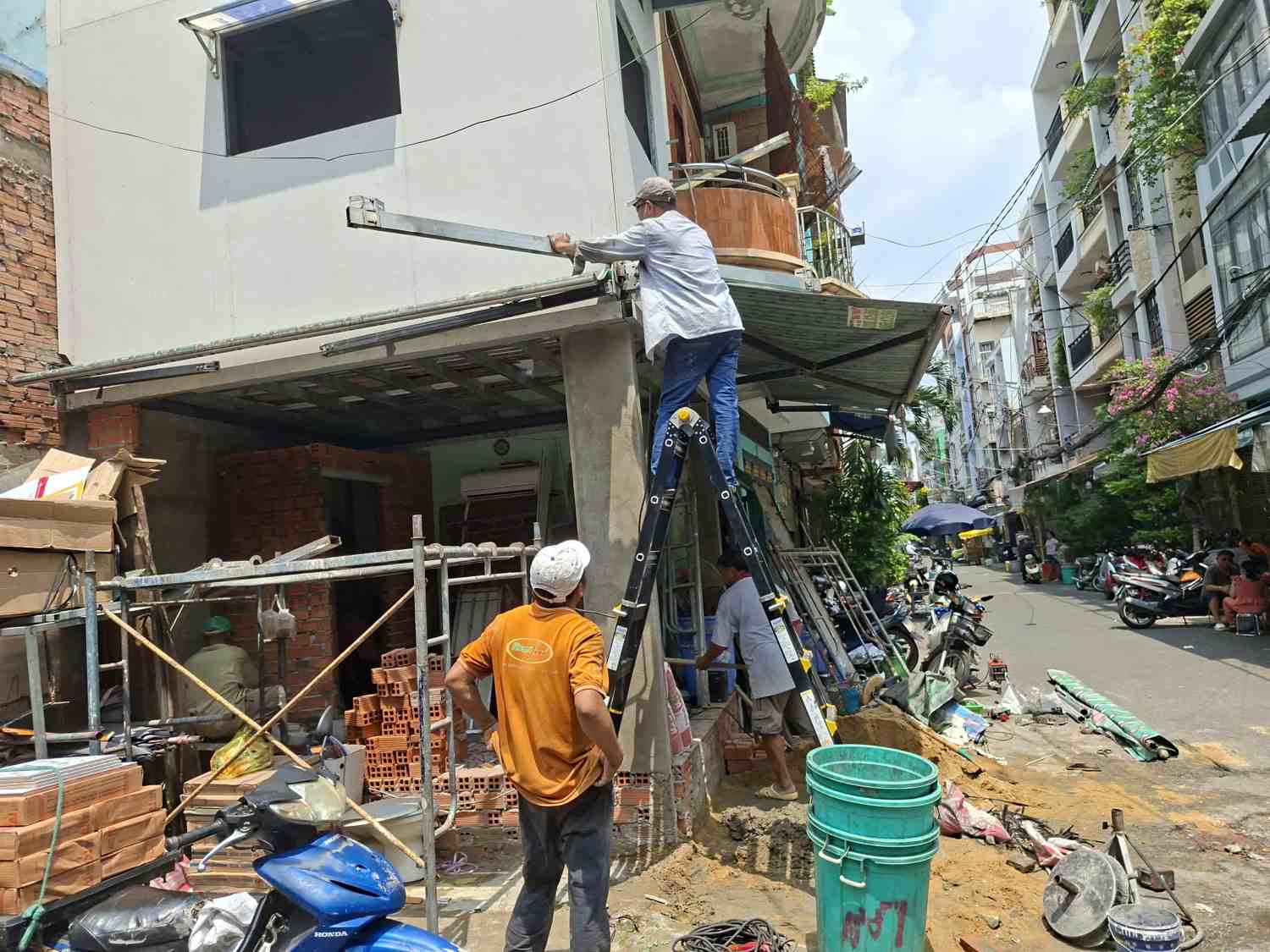 People renovate the remaining houses after handing over the ground for expanding Tran Binh Trong street. Photo: Minh Quan