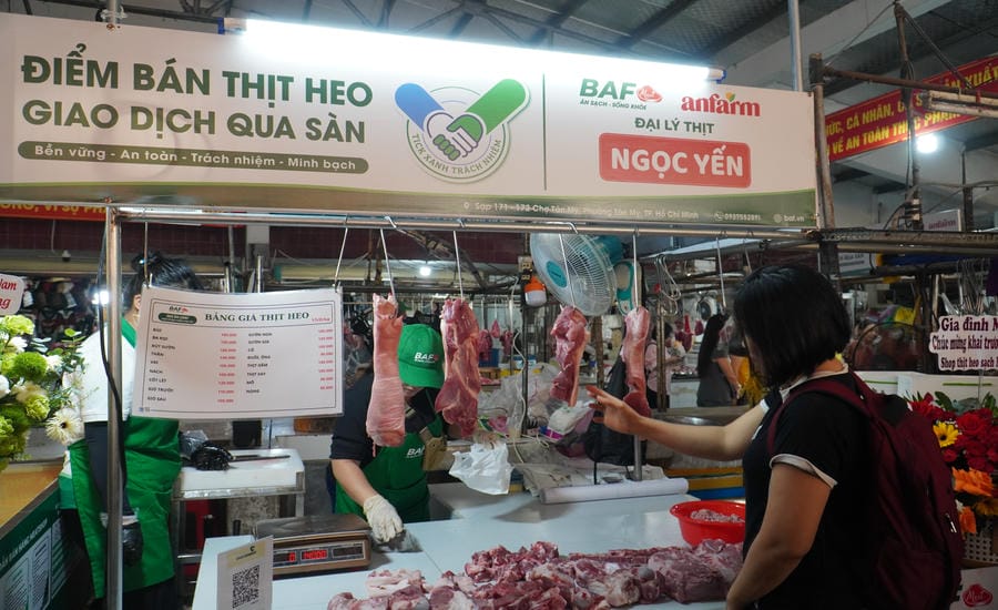 People buy pork at the "Responsibility Green Stick" selling point at Tan My market. Photo: Ngoc Le
