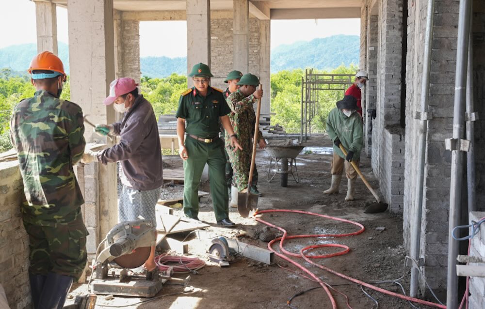 Cán bộ, chiến sĩ Bộ CHQS TP Huế và các công nhân tập trung thi công, đẩy nhanh tiến độ của công trình trường học. Ảnh: Ngọc Minh